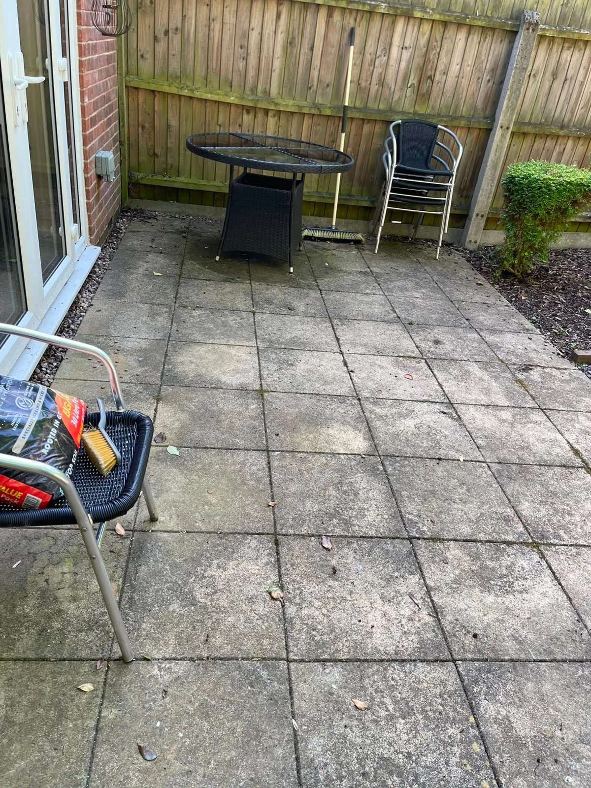 Indian sandstone patio in Littleover, Derby before cleaning, covered in black spot lichen